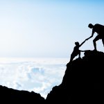 Man And Woman Help Silhouette In Mountains Couple hiking help each other silhouette in mountains sunset and ocean. Male and woman hiker helping each other on top of mountain climbing beautiful sunset landscape.
